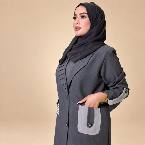 لقطة قريبة لتفاصيل الجيب المتباين والكم في عباية أوربان مازيراتي الرمادية | Close-up of the contrast pocket and sleeve details on the grey Urban Maserati Abaya